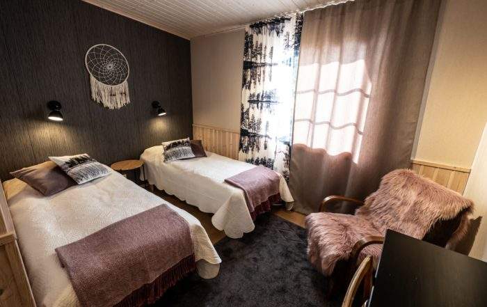 Dvoulůžkový pokoj s oddělenými postelemi v hotelu Wilderness Kortteeri, který se nachází hned vedle hlavní budovy Isokenkäisten Klubi.